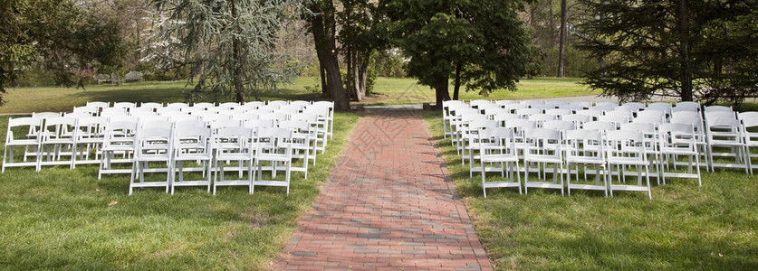 白色折叠椅安排在草坪上进行露天活动图片