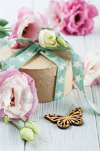 白桌上有星绿色丝带的尤斯托玛花和礼品盒生日贺卡妇背景图片