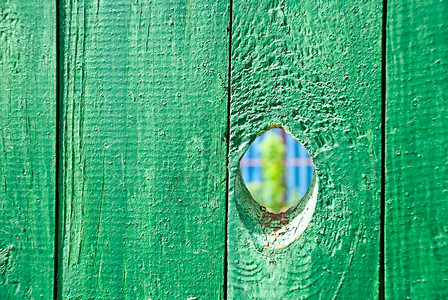 绿色木栅栏上的洞图片