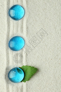 在沙子的蓝色玻璃石头图片