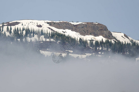 站在云层之上的雪山峰图片