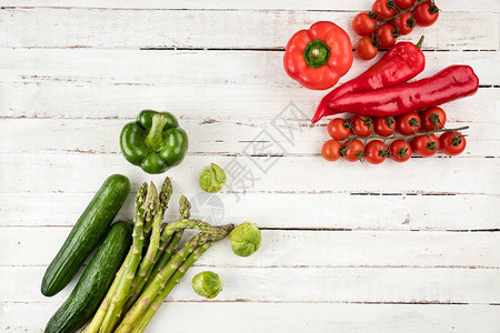 白色木制桌背景的绿色和红绿色新鲜季节蔬菜图片
