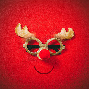 装饰圣诞驯鹿的圣诞眼镜和红底面图片