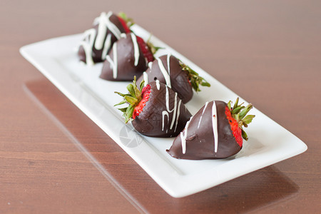 五条巧克力覆盖五行草莓集中在另一条面对的背景图片