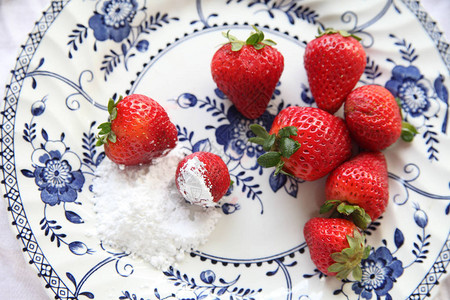 用新鲜草莓和糖粉装饰的盘子的俯视图图片