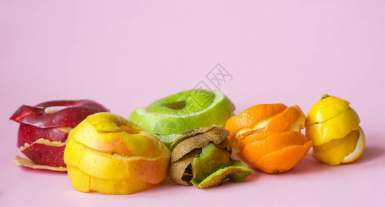 桃红色背景中的猕猴桃橙子柠檬和红绿黄苹果皮作为循环背景图片