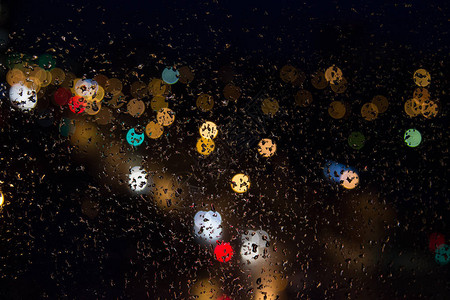 晚上雨滴落在玻璃彩灯上图片