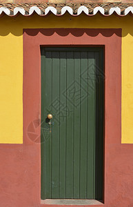 红墙和黄墙上的绿漆木制门葡萄牙马德拉F图片