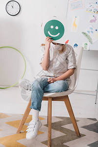 小孩坐在椅子上用微笑的图片