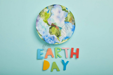 4月22地球日绿地背景上的多彩纸信和行星图片的顶部视图插画