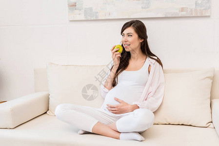 孕妇坐在的沙发上吃苹果图片