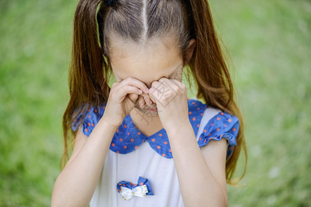 美丽的小女孩和猪尾巴哭泣在夏季公背景图片