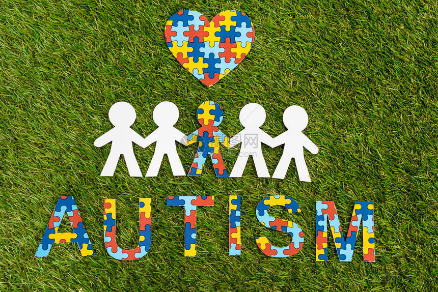 对自闭症拼图的顶端视野写字装饰心脏和特殊孩子在另一个绿图片