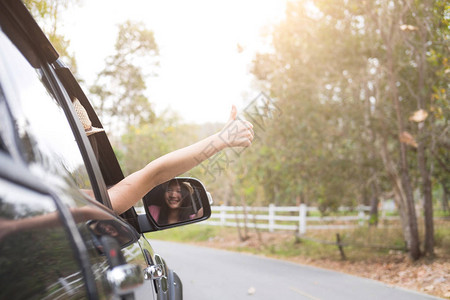 快乐的女士放松手和享受公路之旅汽车旅行是自然旅图片