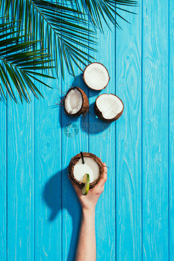 用椰子鸡尾酒碎裂的椰子和棕榈叶以绿图片