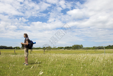 男背包男站在草地上与背景图片