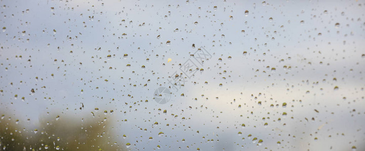 雨滴在模糊的窗口摘要上降雨期间背景模糊的图片