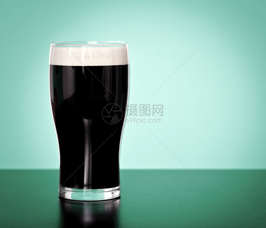 绿色背景中的一品脱爱尔兰黑啤酒图片