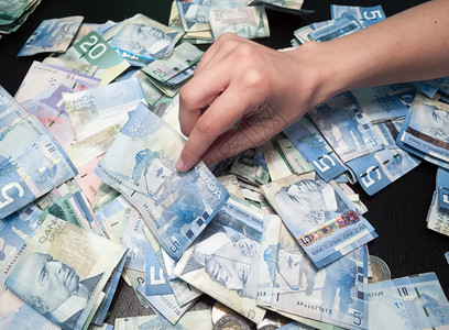 个人用手从纸质货币堆积中挑图片