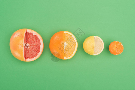 绿色背景的新鲜部分切开的葡萄油橙子图片