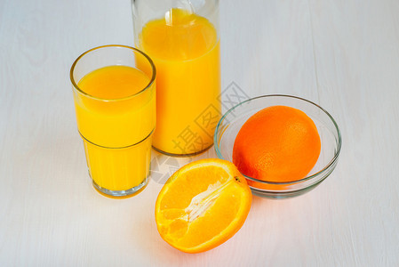 玻璃瓶中的橙汁和白色背景上的玻璃图片