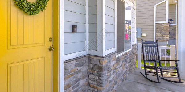 黄色的前门和带摇椅的门廊背景图片