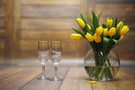 一束黄色郁金香放在地板上的花瓶里黄色郁金香花送给女人节的礼物美丽的黄色花朵在背景图片