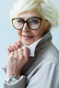 穿着海沟大衣和眼镜的漂亮时尚年长女士背景图片