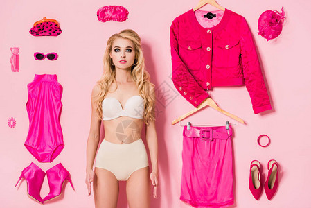 穿内裤的漂亮女孩穿着粉红色娃概念的衣服和饰品图片