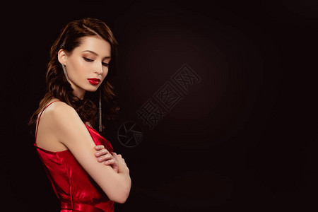 身着红裙子的美女的侧视角与黑色背景图片