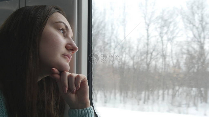 年轻女子在火车上骑马时仰望着窗子图片