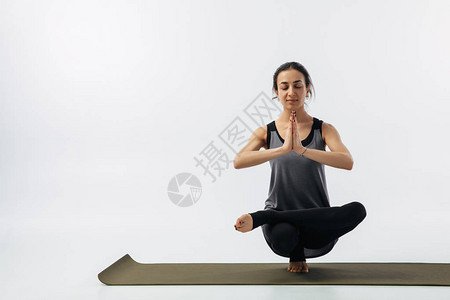 女在瑜伽垫上练习的脚趾站立图片