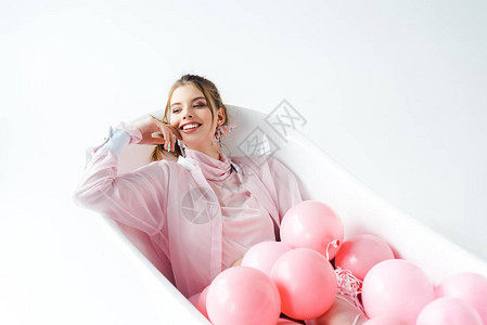 快乐的年轻女人躺在浴缸里背景图片