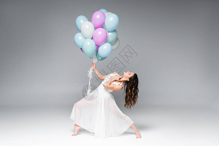 穿着白色礼服的年轻美女芭蕾舞者带着灰色背景的图片