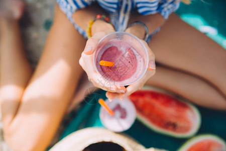 夏日野餐时喝西瓜冰沙的年轻美女图片