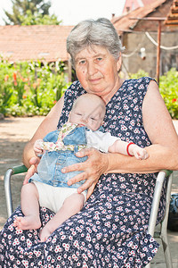 祖母在户外抱着孙女的肖像图片