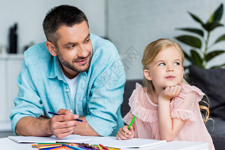 爸和可爱的小女儿在家里一起用彩背景图片