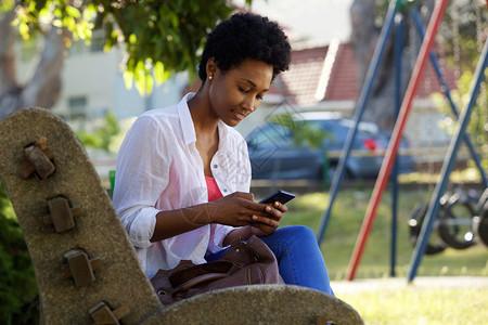 一位坐在公园长椅上的年轻美女的肖像背景图片