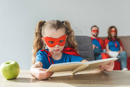 穿着超级英雄服装的女生读书而超级图片