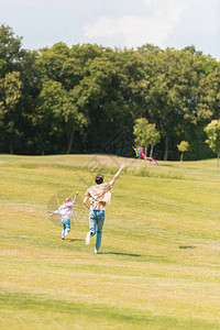 父亲和女儿的背影在草地上图片