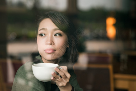 可爱的越南女人喝咖啡透过咖啡图片