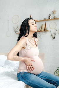 孕妇在卧室内有疼痛和触摸肚子图片