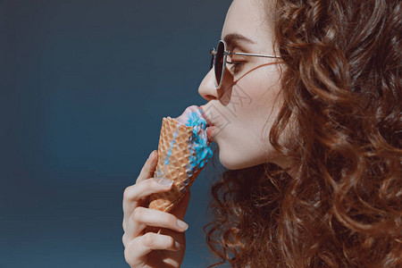 戴墨镜吃冰淇淋的红发女孩特写肖图片