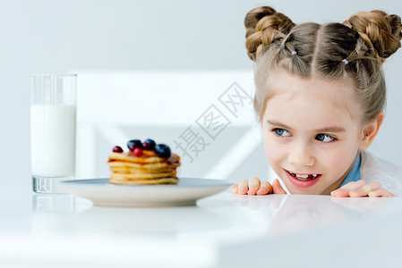 看着家里做的煎饼桌上有浆果和蜂蜜的豆子还有小孩图片