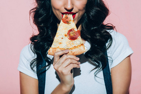 在粉红色背景下吃披萨的女人的短片背景图片
