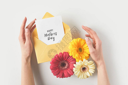 带信封Gerbera鲜花和快乐的母亲用灰色的贺卡图片