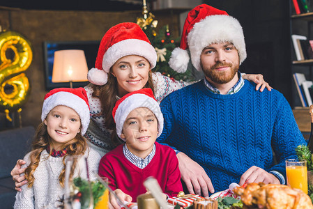 年轻的家庭在餐桌旁圣诞晚餐图片
