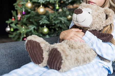 在圣诞节时间坐在沙发上被抱着Teddy熊和坐在沙发图片