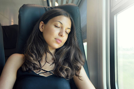年轻漂亮的女人坐在火车上睡觉火车乘客坐地铁高清图片素材