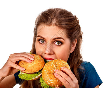 女人吃两个汉堡学生吃快餐女孩咬了两个小汉堡女孩想吃很多垃圾在黑色背景上宣传快餐大忙背景图片